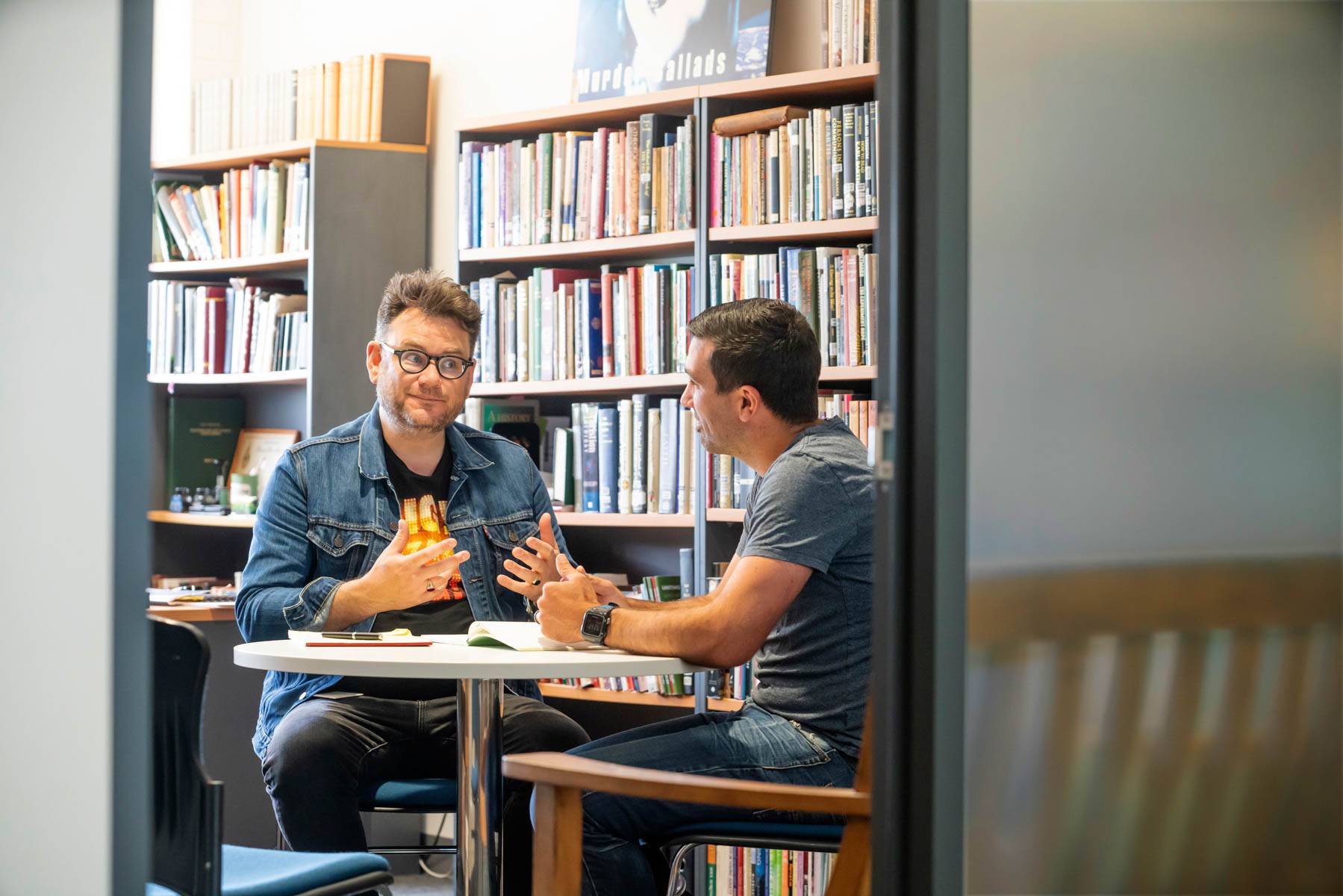 Uniting College for Leadership and Theology students talk around a library table with open books